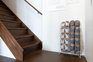 a staircase with a rack of shoes under the stairs at Cafe & Guest House Nagonoya in Nagoya