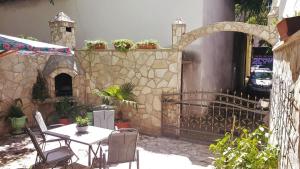 a patio with a table and chairs and a stone wall at Moonrise Apartment in Mostar