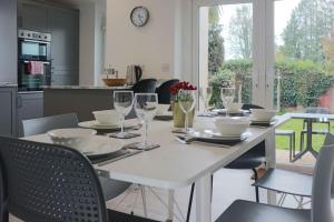 a white table with glasses and plates on it in a kitchen at Causey Lodge superb comfy home in Exeter by StayStay in Exeter