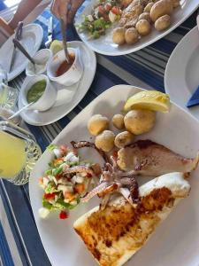 una mesa con tres platos de comida. en Weybeach3 ocean frontline,sea view,private terrace, en La Santa