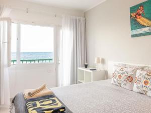 1 dormitorio con 1 cama y vistas al océano en Weybeach3 ocean frontline,sea view,private terrace, en La Santa