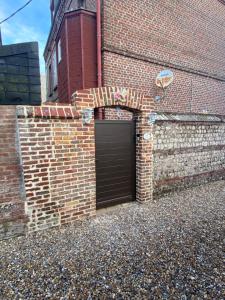 un edificio de ladrillo con una puerta de garaje. en Chambre D'hôte Villa Maurice, en Étretat