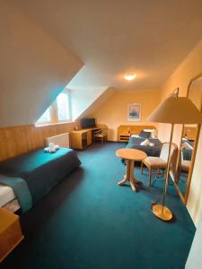ein Hotelzimmer mit einem Bett, einem Tisch und einem Sofa in der Unterkunft hotel Nautilus in Chodov