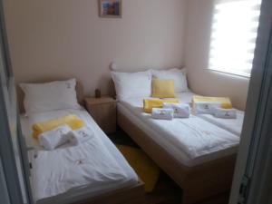 2 camas individuales en una habitación con toallas. en Apartmani Jela Tara en Kaludjerske Bare