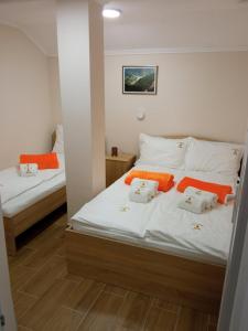 1 dormitorio con 2 camas con sábanas de color naranja y blanco en Apartmani Jela Tara en Kaludjerske Bare