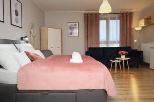 een woonkamer met een bed met een roze deken bij Lucky-Time pl - 35 - Ostrów Tumski in Wrocław