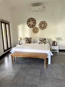 a bedroom with a large bed and two lamps at Asri Villas Bingin in Uluwatu
