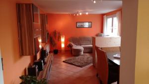 ein Wohnzimmer mit orangefarbenen Wänden und einem Sofa in der Unterkunft Am Sachsenring in Bad Driburg