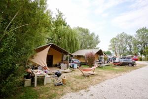 a camping site with a tent and a table and chairs at Glamping Lac d'Orient in Mesnil-Saint-Père