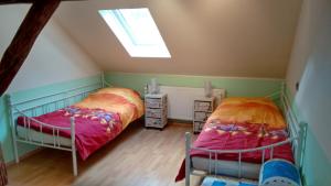 Schlafzimmer im Dachgeschoss mit 2 Betten und einem Dachfenster in der Unterkunft Am Sachsenring in Bad Driburg