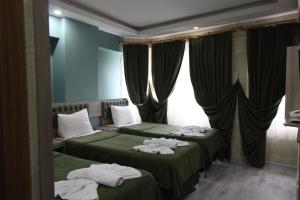 イスタンブールにあるKaya Madrid Hotelのホテルルーム内のベッド2台(タオル付)