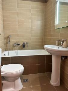 a bathroom with a toilet and a sink and a bath tub at EVa's Luxury Apartments No 1 in Áyios Spirídhon