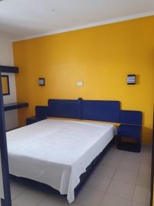 ポルティマンにあるApartamento 823 club praia da Rocha !!!の黄色い壁のドミトリールームの青いベッド1台分です。