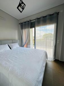 a bedroom with a large white bed and a window at EVa's Luxury Apartments No 1 in Áyios Spirídhon