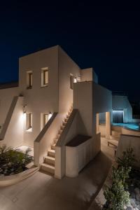 a house with a staircase leading up to it at night at Areos Luxury Suites in Vóthon