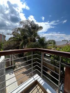 a balcony with a view of the beach and palm trees at EVa's Luxury Apartments No 1 in Áyios Spirídhon