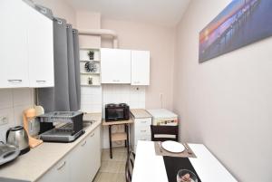 eine Küche mit weißen Schränken und einer Arbeitsplatte in der Unterkunft Like Your Home Apartment Thessaloniki in Thessaloniki