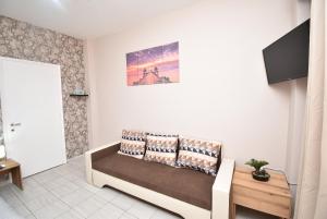 ein Wohnzimmer mit einem Sofa und einem TV in der Unterkunft Like Your Home Apartment Thessaloniki in Thessaloniki