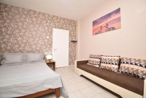 1 dormitorio con 1 cama y 1 sofá en Like Your Home Apartment Thessaloniki, en Tesalónica