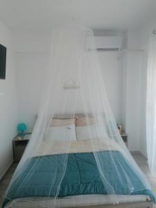a bed with a net over it in a room at Crystal Blue Apartments in Nea Kalikratia