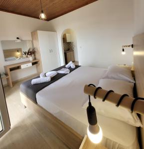 a bedroom with a large white bed and a bathroom at ROULA STUDIOS in Tsilivi