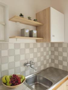 蒂錫利維的住宿－ROULA STUDIOS，厨房配有水槽和一碗水果