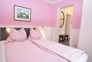 a bedroom with pink walls and a bed with pink pillows at fewo1846 - Pauline - zauberhafte Wohnung für 2 Personen mit Terrasse und Garten in Glücksburg