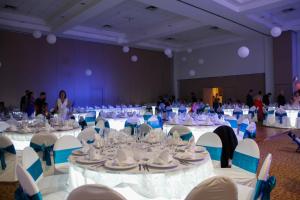 un gran salón de banquetes con mesas y sillas blancas en Hotel Marbella, en Manzanillo