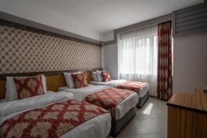 a hotel room with two beds and a window at Mevre Hotel in Antalya