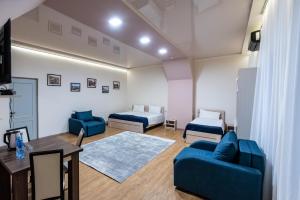 a room with two beds and a couch and a table at Tiflis Hotel in Tbilisi City