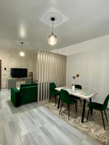 ein Wohnzimmer mit einem Tisch und grünen Stühlen in der Unterkunft Tanya Apartments Nord10 in Mamaia Nord – Năvodari