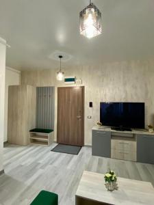 ein großes Wohnzimmer mit einem TV und einer Tür in der Unterkunft Tanya Apartments Nord10 in Mamaia Nord – Năvodari