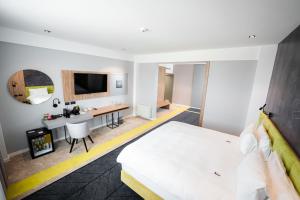 a hotel room with a bed and a desk at Mandachi Hotel & SPA in Suceava