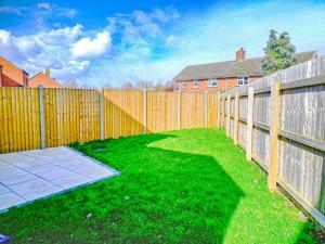 a backyard with a wooden fence and green grass at Lancaster House in Lincoln