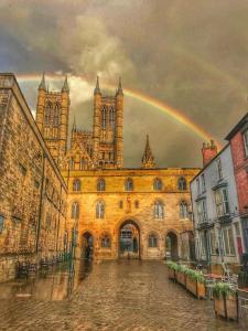 an old building with a rainbow in the sky at Lancaster House in Lincoln