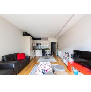ein Wohnzimmer mit einem Sofa und einer Küche in der Unterkunft Bitcoin Adorabile suite nel cuore del magnifico Chiswick in London
