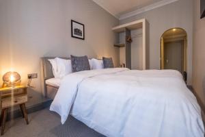a bedroom with a large white bed and a table at The Arran, St Andrews in St. Andrews