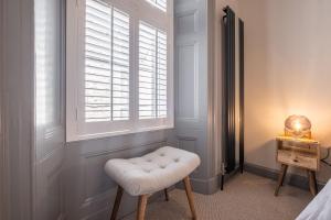 a white stool in a room with a window at The Arran, St Andrews in St. Andrews