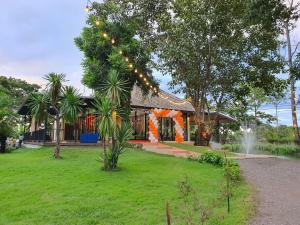 una casa con una cadena de luces en un patio en The Grand Jamjuree Resort Lamphun 