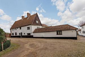 a large white house with a brown roof at The Retreat in Tibenham +6 photos