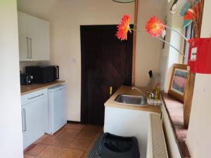 a kitchen with a sink and a vase with flowers at The Retreat in Tibenham