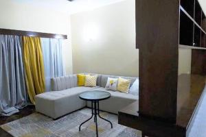 sala de estar con sofá y mesa en A cosy Mustard Haven-Shanzu en Mombasa