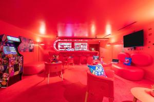 a red room with red chairs and a bar at Appart'City Collection Paris Vélizy in Vélizy-Villacoublay