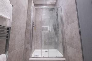 a shower with a glass door in a bathroom at The Arran, St Andrews in St. Andrews