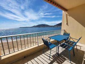 Un balcón con mesa y sillas y la playa. en Sudio bord de mer Ajaccio, en Ajaccio