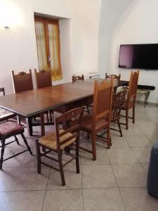 une salle à manger avec une grande table et des chaises en bois dans l'établissement Liguria di Ponente Albenga collina, à Albenga