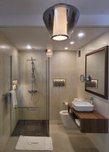 a bathroom with a shower and a sink and a toilet at Appartements Lamblin in Abidjan