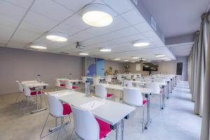 a classroom with white tables and white chairs at Appart'City Collection Paris Vélizy in Vélizy-Villacoublay