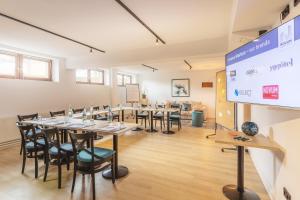 a conference room with tables and chairs and a projection screen at Novum Hotel City Nord in Hamburg