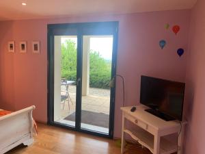 a bedroom with a sliding glass door leading to a patio at Mur-Mûres in Mûres-les Balmettes